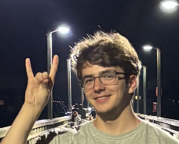 Student Bernard Boden raises hand to show NC State's wolf ears sign.